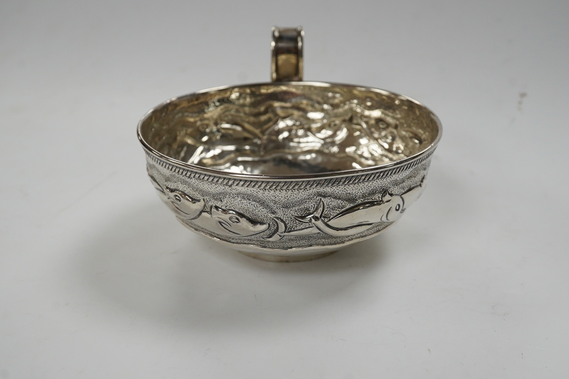 A Greek Lalaounis 800 standard white metal single handled cup, embossed with fish, diameter 11.5cm, 135 grams. Condition - fair